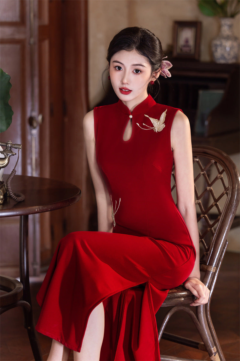 Wine red qipao seated, showing how the side slit opens