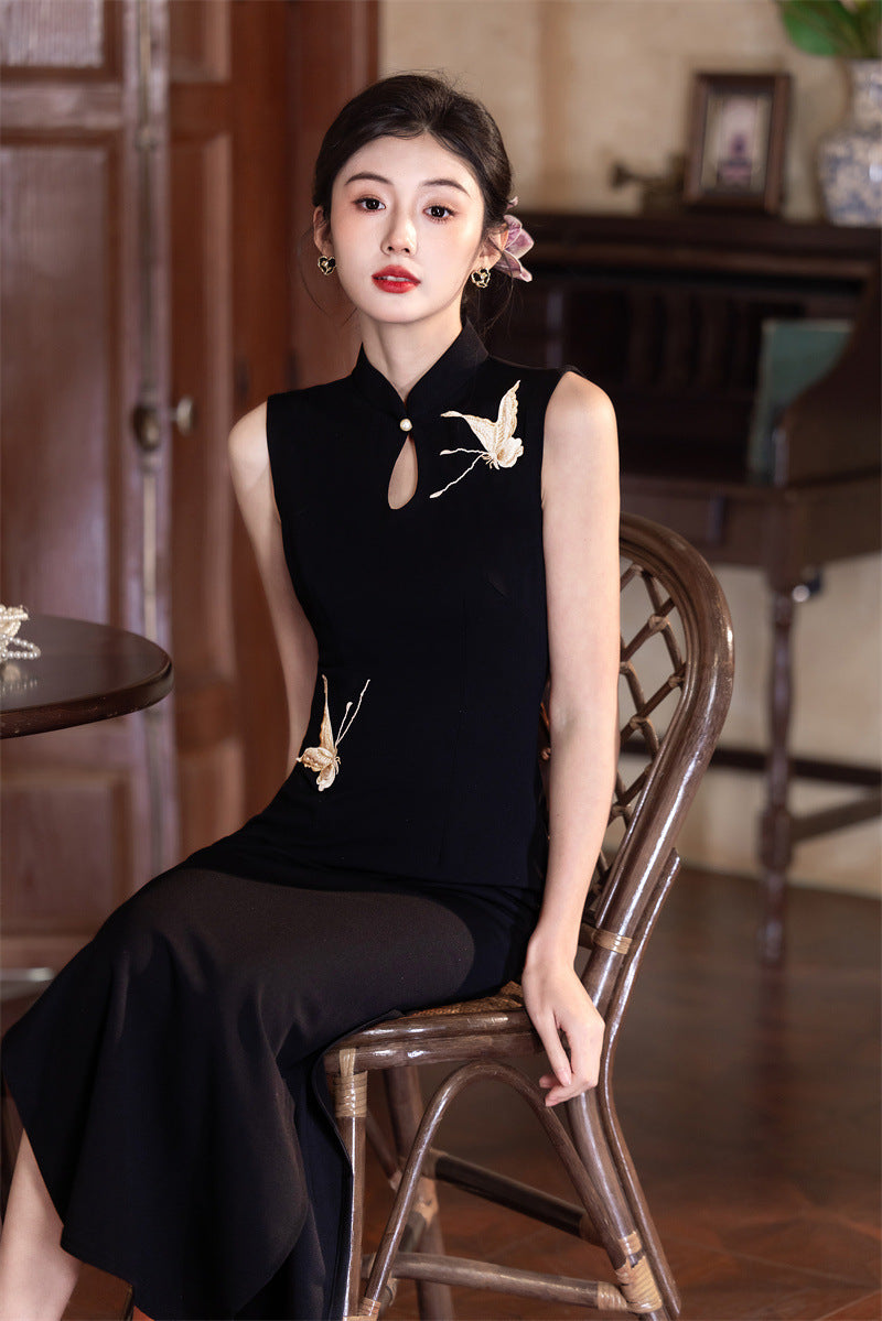 Black crane qipao seated, showing how the side slit opens