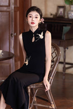 Black crane qipao seated, showing how the side slit opens