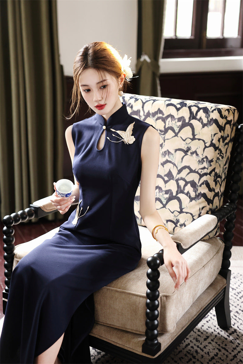 Navy crane qipao seated, showing how the side slit opens
