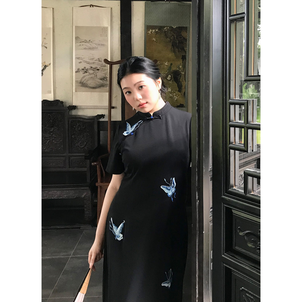 Black butterfly embroidered qipao dress, three-quarter view
